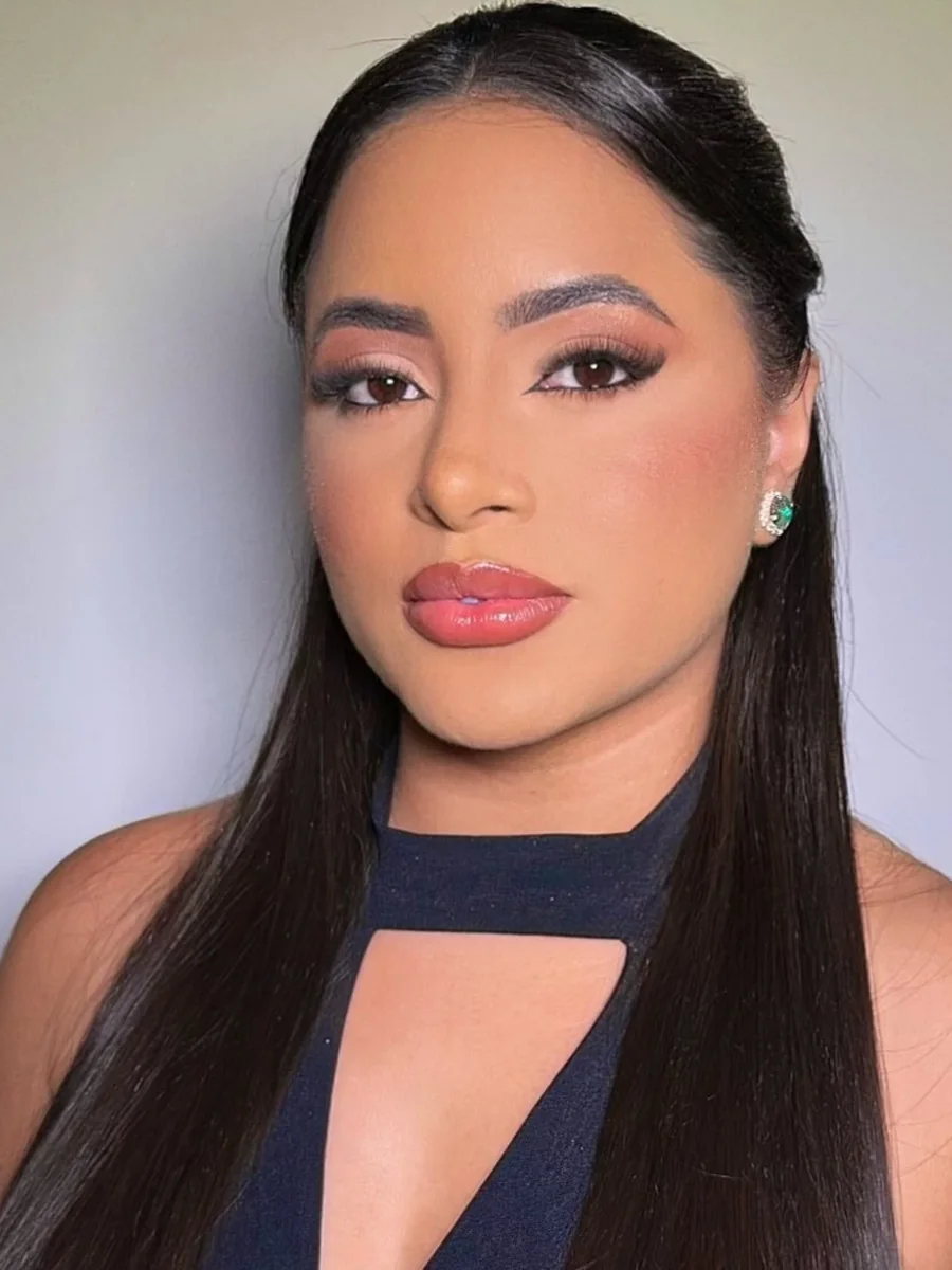 Maquiagem em tons rosados, delineado e penteado semipreso.