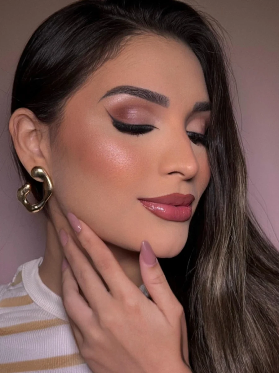 Maquiagem com delineado preto e tons rosados.
